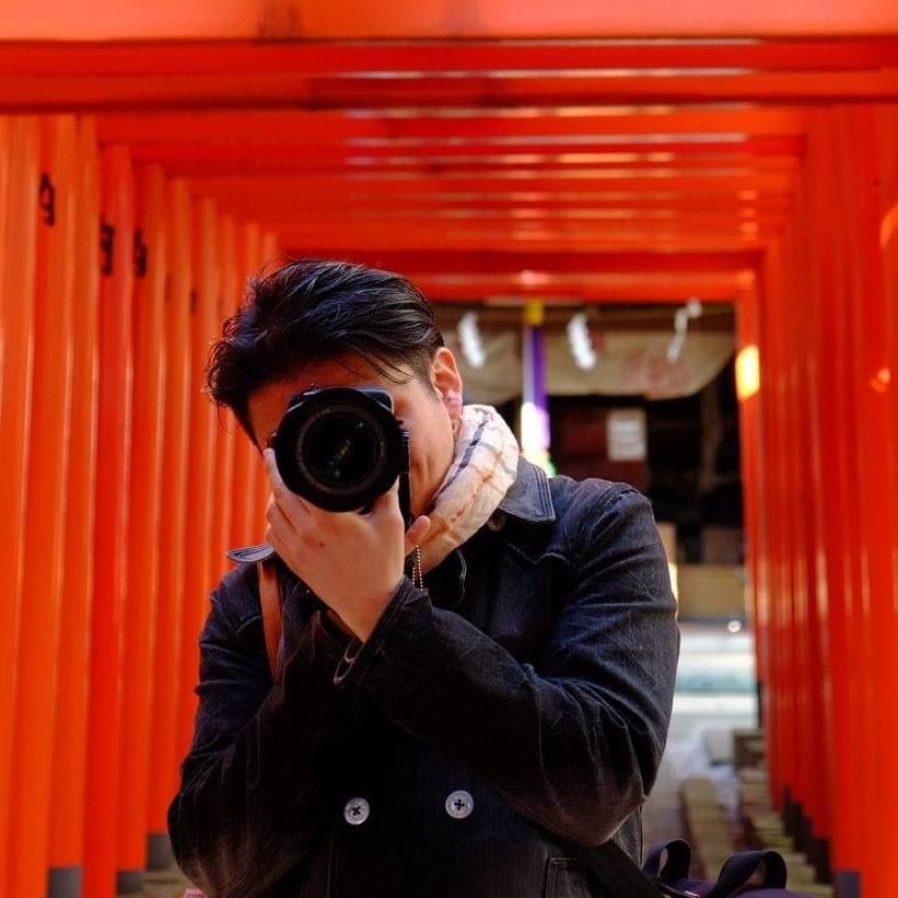 鳥居の下でカメラを構える人物